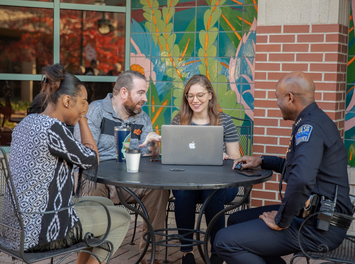 four people sit at courtyard table four people sit at courtyard table